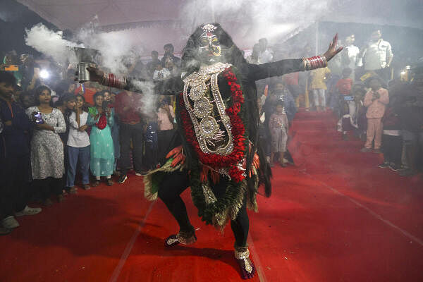 An artist dressed as Goddess Kali performs during ‘Kalindi Mahotsav’, in Prayagraj.