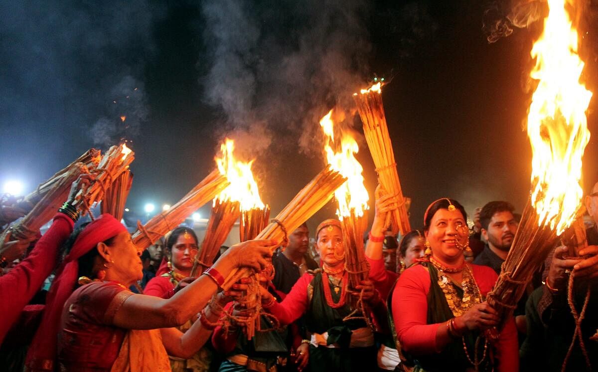 People participate in the 'Igas Bagwal' celebration at the Doon University Campus, in Dehradun.