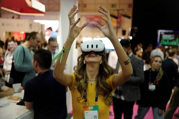 A woman tries augmented reality goggles during the Web Summit, in Lisbon, Portugal.