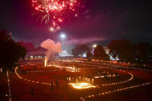 Athletes light candles and burst firecrackers during 'track pujan' ceremony on the occasion of ‘Dev Uthani Ekadashi’ at a school ground, in Prayagraj.