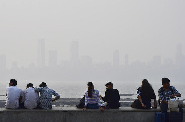 People visit the Marine Drive as haze engulfs the city skyline in Mumbai, Saturday, Nov. 16, 2024