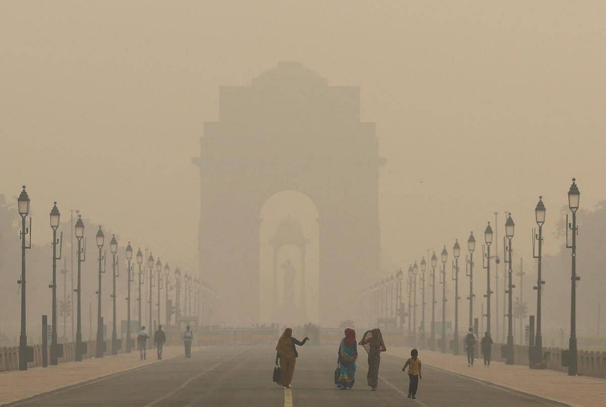 Women walk on a road near India Gate as the sky is enveloped with smog after Delhi's air quality worsened due to air pollution, in New Delhi, India, November 19, 2024.