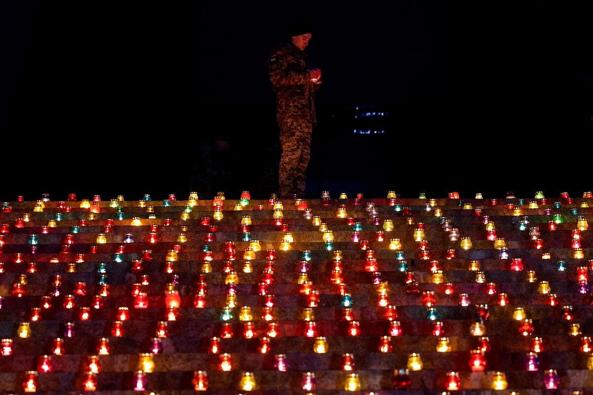 A military cadet lights a candle during a commemorative ceremony on the 1000th day of Russia's full scale attack on Ukraine, in front of the 'Motherland' monument in Kyiv, Ukraine November 19, 2024.