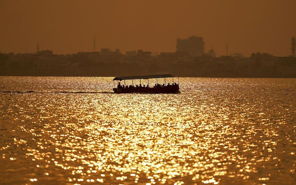 Tourists ride a ferry during sunset, in Ajmer, Rajasthan, Thursday, Nov. 21, 2024.