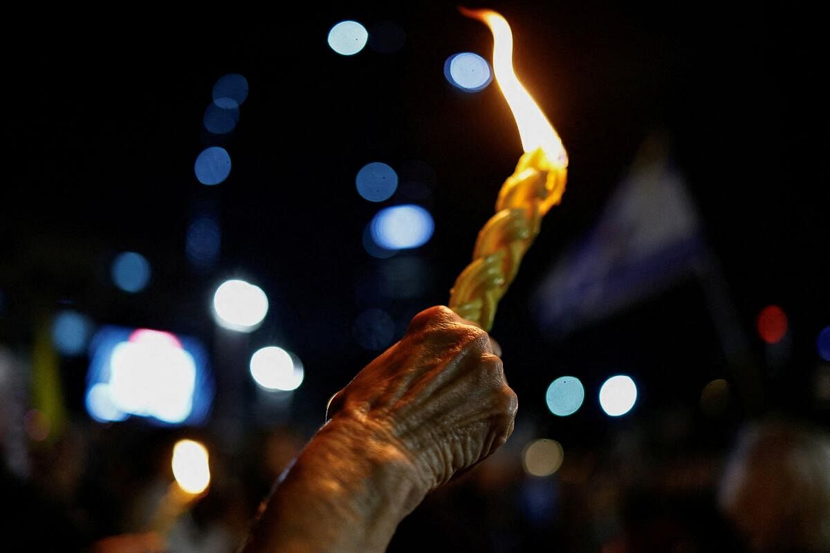 A person holds a candle as Israelis protest against the government and to show support for the hostages who were kidnapped during the deadly October 7 2023 attack, amid the ongoing conflict in Gaza between Israel and Hamas, in Tel Aviv, Israel November 23, 2024.