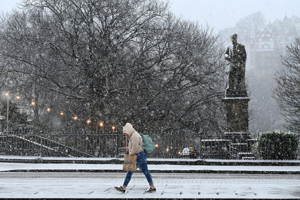 A person walks amidst snowfall during Storm Bert, along Princes Street in Edinburgh, Scotland, Britain, November 23, 2024.