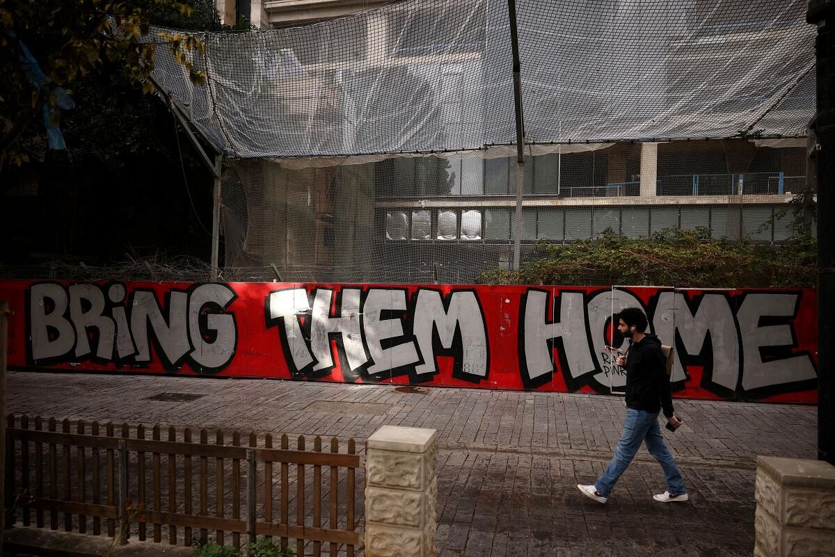 A man walks past graffiti calling for the release of the hostages kidnapped during the deadly October 7, 2023 attack by Hamas, amid the ongoing conflict in Gaza between Israel and Hamas, in Tel Aviv, Israel.