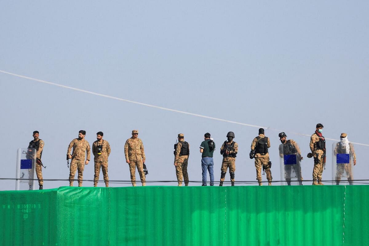 Pakistani Army soldiers stand guard over a shipping container used to block the road leading to the parliament house, to prevent an anti-government protest rally by supporters of the former Pakistani Prime Minister Imran Khan's party Pakistan Tehreek-e-Insaf (PTI) demanding the release of Khan, in Islamabad, Pakistan.