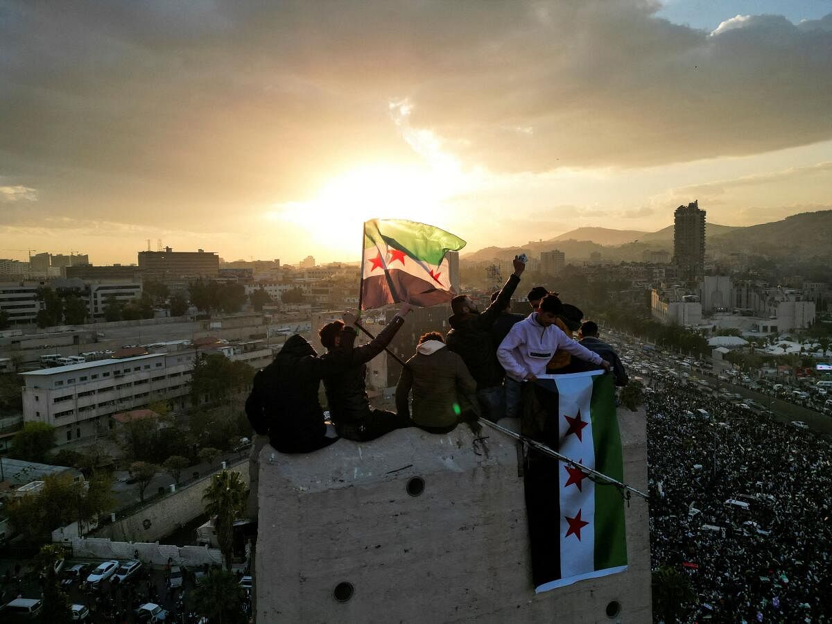 A drone view shows people waving flags adopted by the new Syrian rulers during celebrations in Umayyad Square, after the ousting of Syria's Bashar al-Assad, in Damascus, Syria.