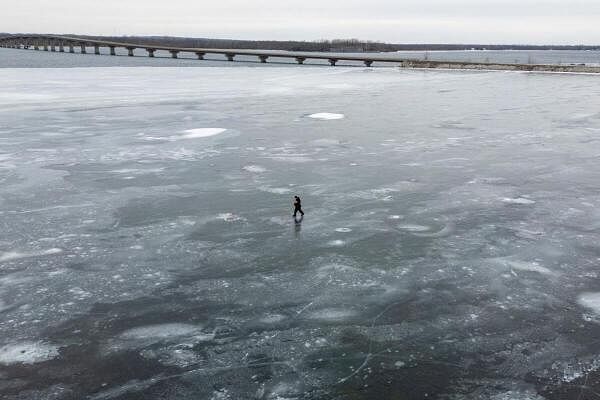 An ice fisherman walks on a frozen Lake Champlain near Alburgh, Vermont, U.S., January 19, 2025.