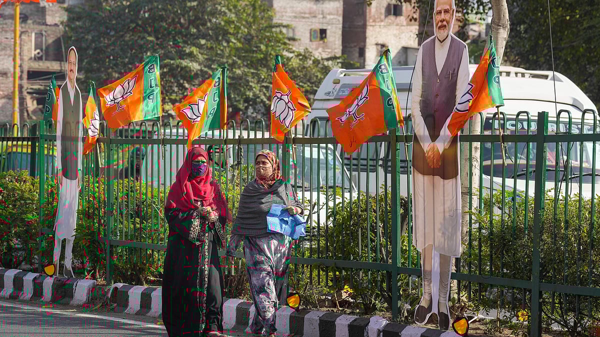 Pedestrians pass by a cutout of Prime Minister Narendra Modi amid preparations for the oath-taking ceremony of the New Delhi Government, near the Ramlila Maidan in New Delhi.