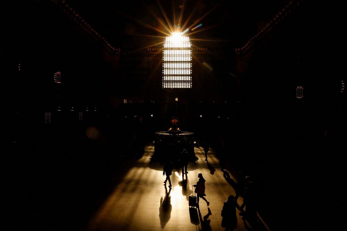 People walk in silhouette through Grand Central Station during morning time in New York City, US.