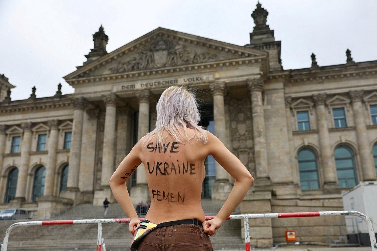 An activist of the women's rights group FEMEN protests against Russia's invasion of Ukraine, in front of the Reichstag building, the seat of the Bundestag, the lower house of German federal parliament, on the day of the 2025 general election, in Berlin, Germany