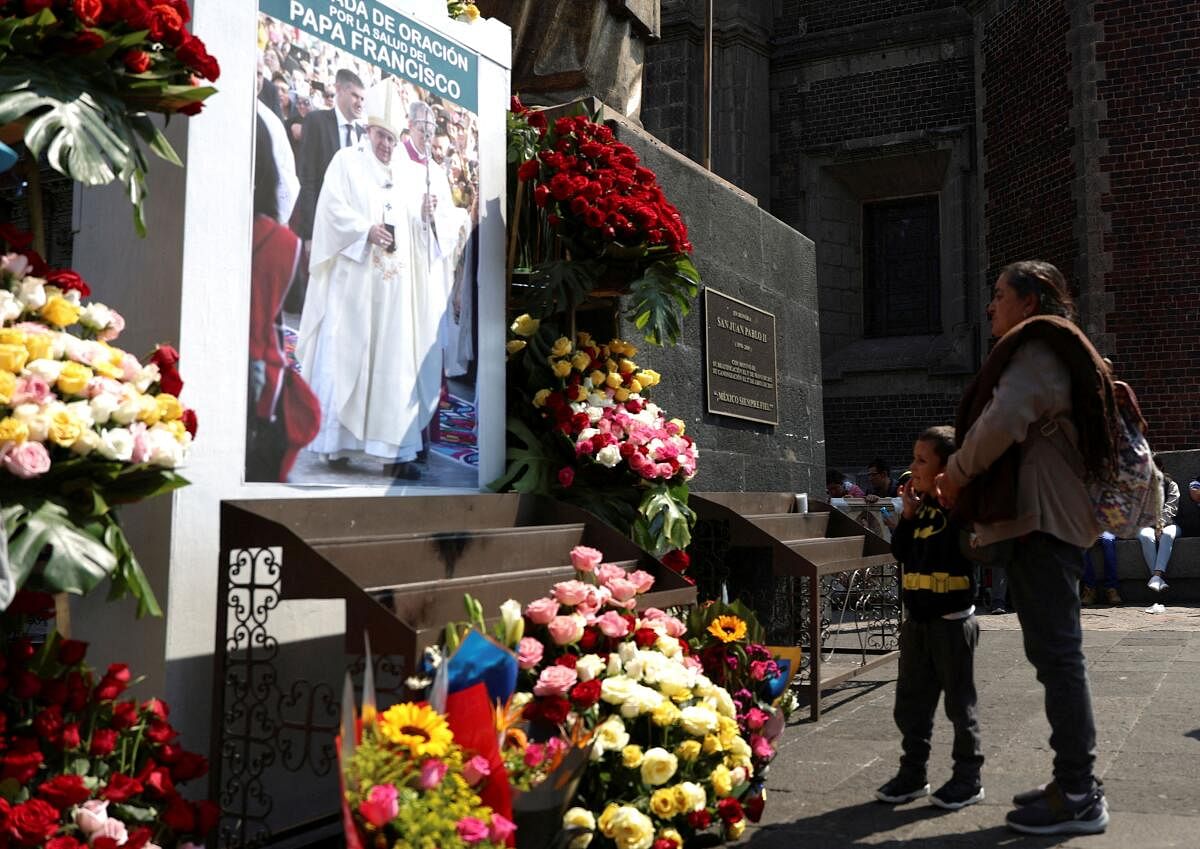 People stand in front of an image of Pope Francis at the Basilica of Guadalupe, in Mexico City, Mexico