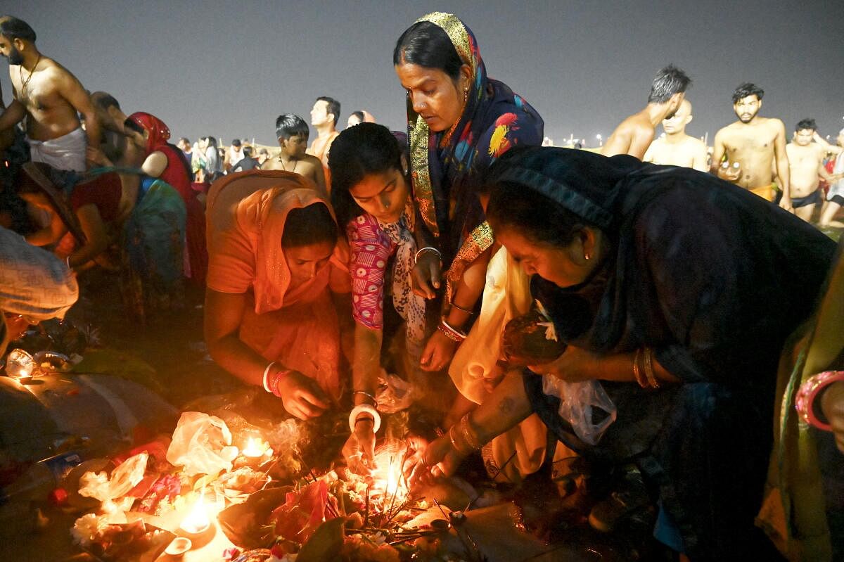 Devotees perform rituals after taking a holy dip in the Ganga river on the occasion of Maha Shivratri festival during the ongoing Maha Kumbh Mela 2025, in Prayagraj