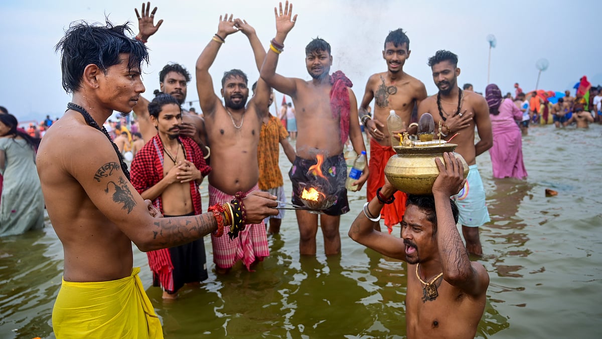 Devotees perform rituals as they take a holy dip at Sangam on the occasion of Maha Shivratri during the Maha Kumbh Mela 2025.