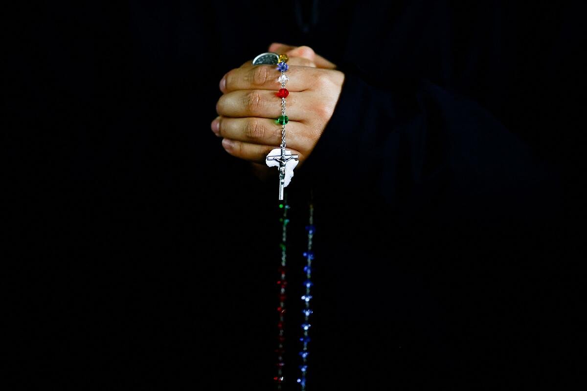 A person holds a rosary during a prayer service at St. Peter's Square, as Pope Francis continues his hospitalisation, at the Vatican