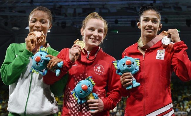 Gold medalist Canada's Diana Weicker, silver medalist India's Babita Kumari and bronze medalist Nigeria's Bose Samuel during the medal ceremony of the women's freestyle 53 kg Nordic category at the Commonwealth Games 2018 in Gold Coast, on Thursday. (PTI Photo)