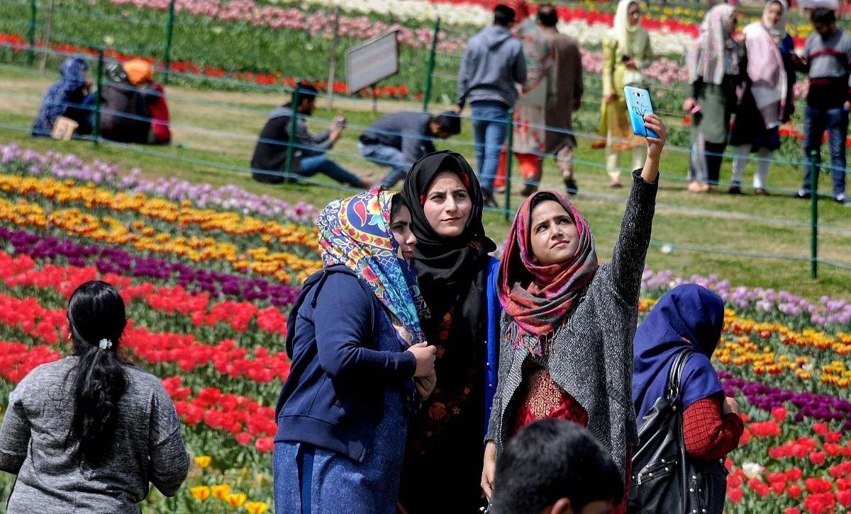 Visitors take a selfie at the Indira Gandhi Memorial Tulip Garden, believed to be Asia's largest tulip garden, in Srinagar on Sunday. PTI Photo