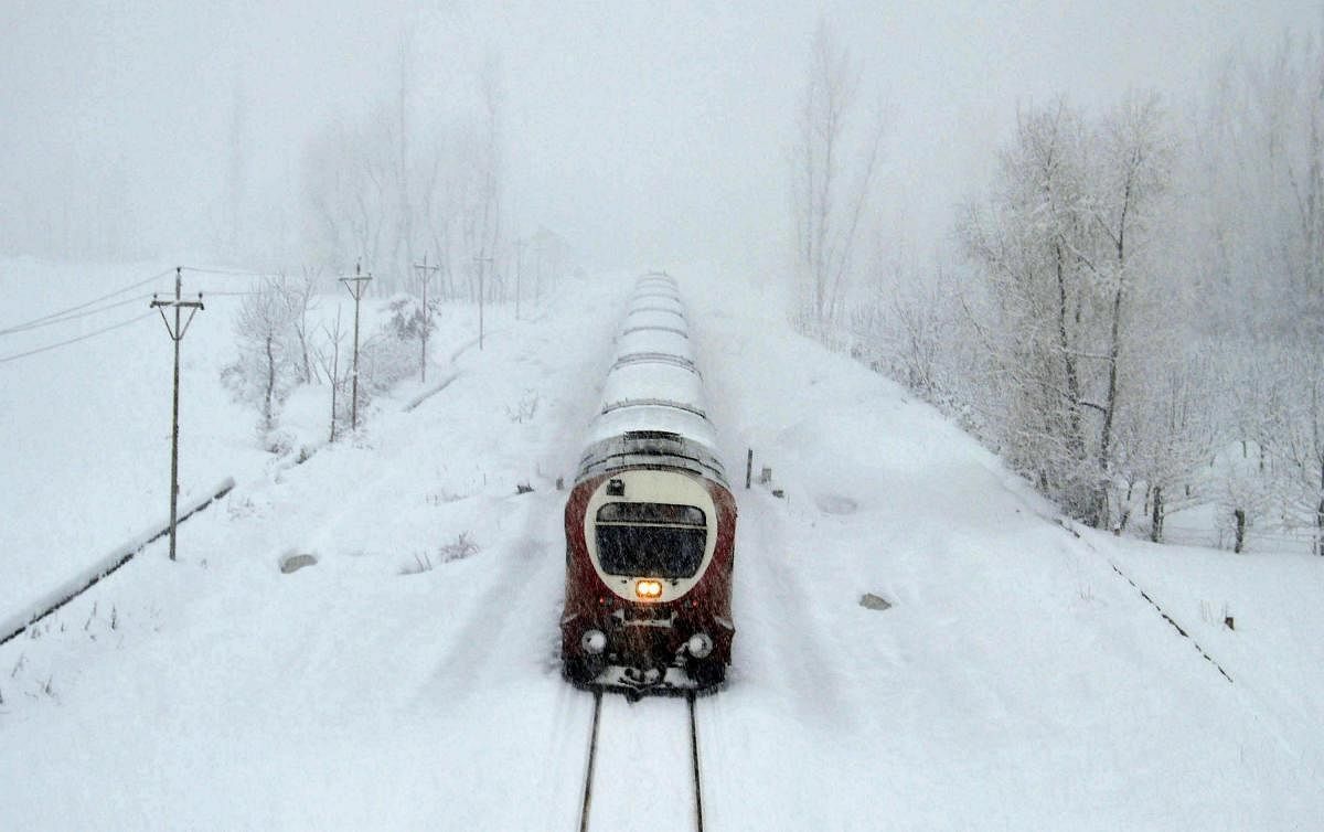A train moves on the snow covered Srinagar-Qazigund railyway track during heavy snowfall,at Anantnag district of south Kashmir. PTI Photo