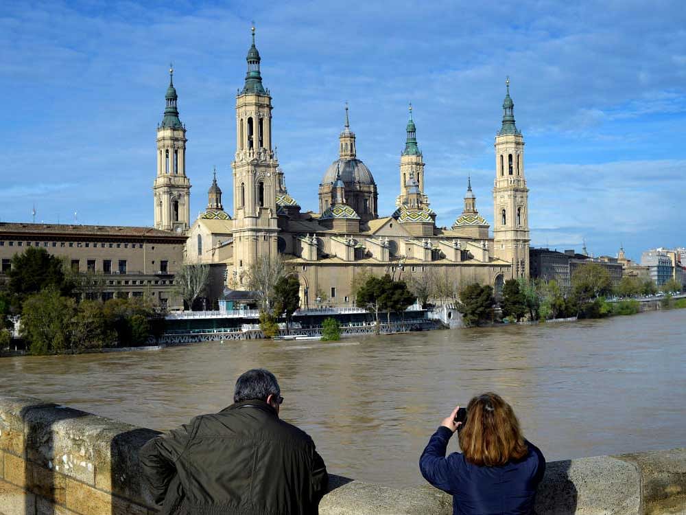 A couple observes the River Ebro close to overflowing, following heavy rains and snow melt, in front of the Cathedral-Basilica of Our Lady of the Pillar, in Zaragoza, Spain. Reuters Photo