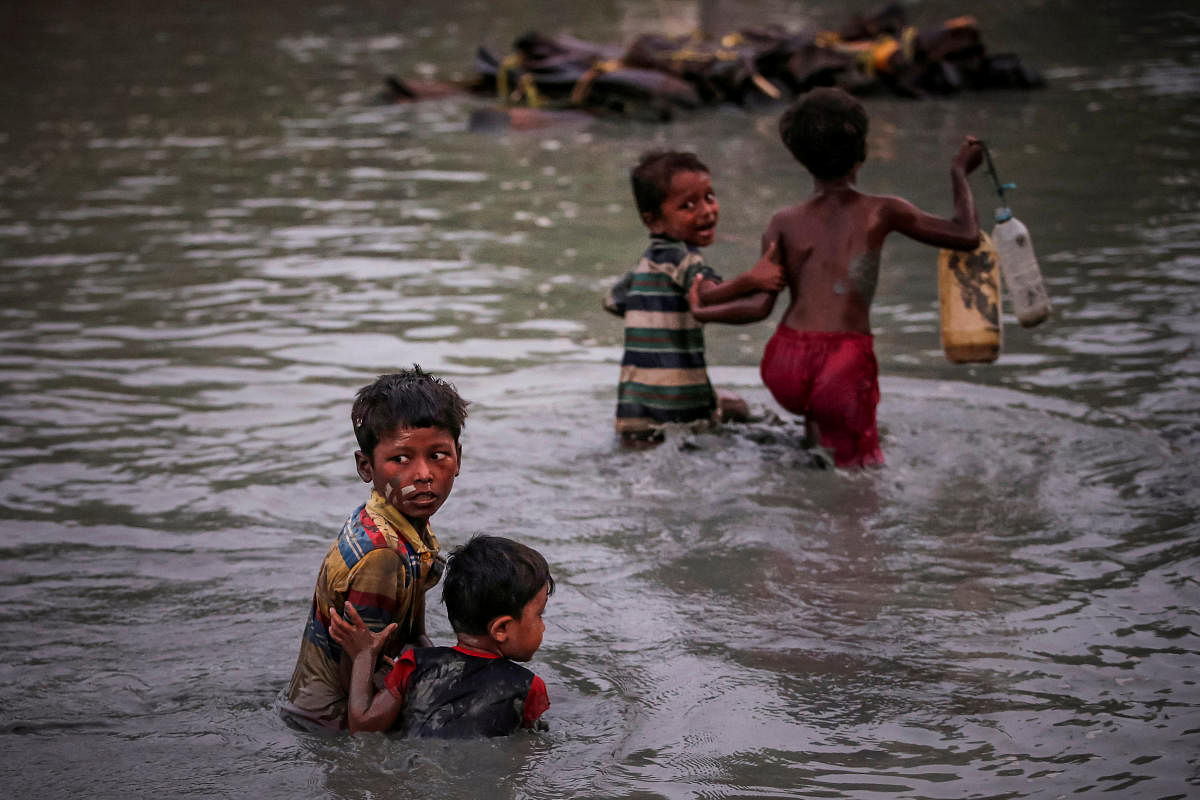 Rohingya siblings fleeing violence hold one another as they cross the Naf River along the Bangladesh-Myanmar border in Palong Khali, near Cox’s Bazar, Bangladesh November 1, 2017. REUTERS/Adnan Abidi