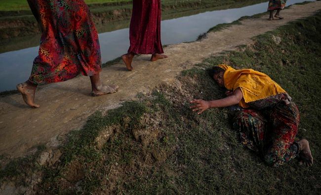 An exhausted Rohingya refugee fleeing violence in Myanmar cries for help from others crossing into Palang Khali, near Cox's Bazar, Bangladesh November 2, 2017. REUTERS/Hannah McKay