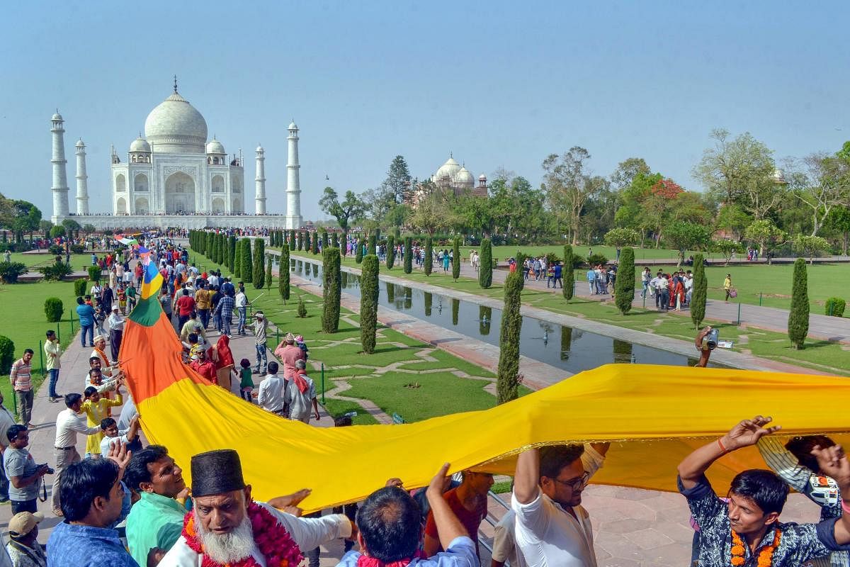 People of all the societies offer a 1111 meter long Satarangi sheet on the 363rd Urs of Shah Jahan at Taj Mahal in Agra on Sunday. PTI