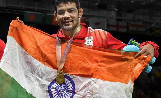 India's Sushil Kumar celebrates holding tricolour after winning a gold medal in the men's freestyle 74kg wrestling final bout against South Africans' Johannes Botha at the Commonwealth Games 2018 in Gold Coast, on Thursday. (PTI Photo)
