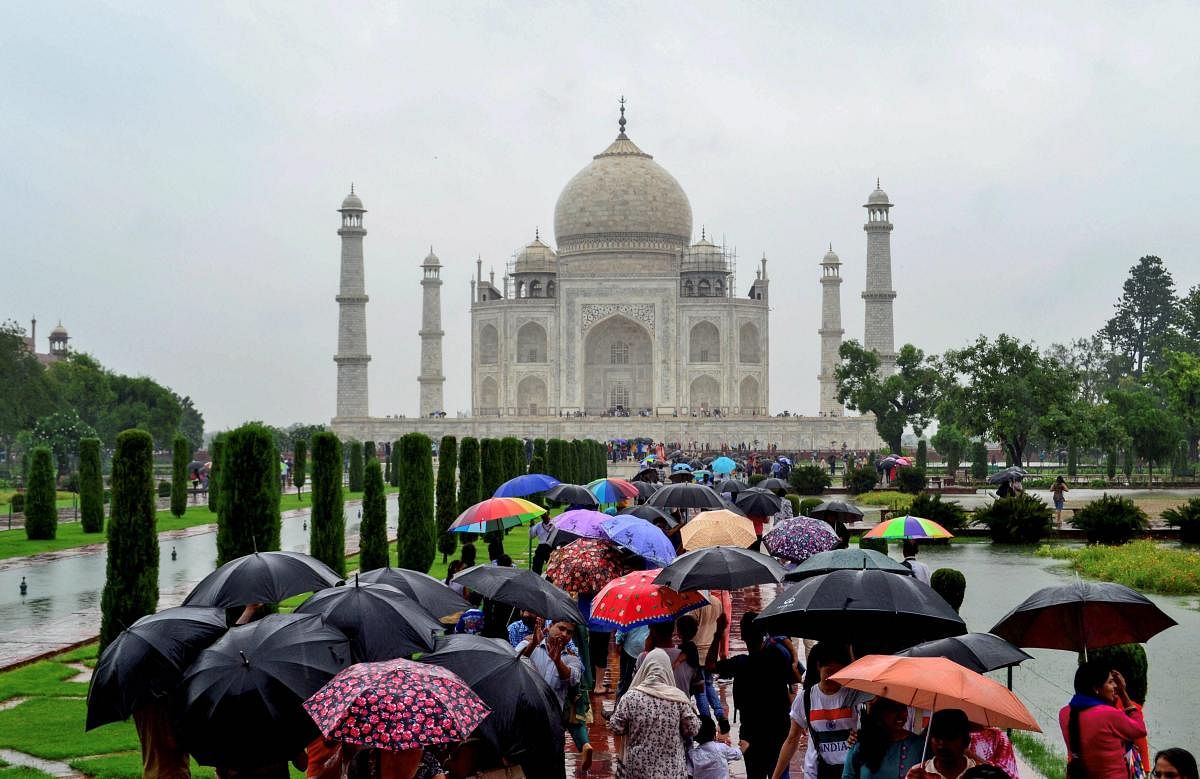 Tourists visit Taj Mahal on a rainy day, in Agra. (PTI Photo)