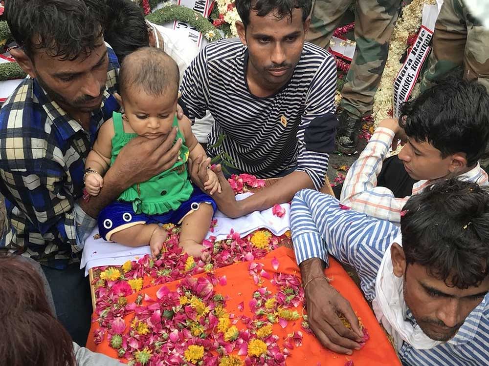 Martyr's child sits on his coffin, people go emotional