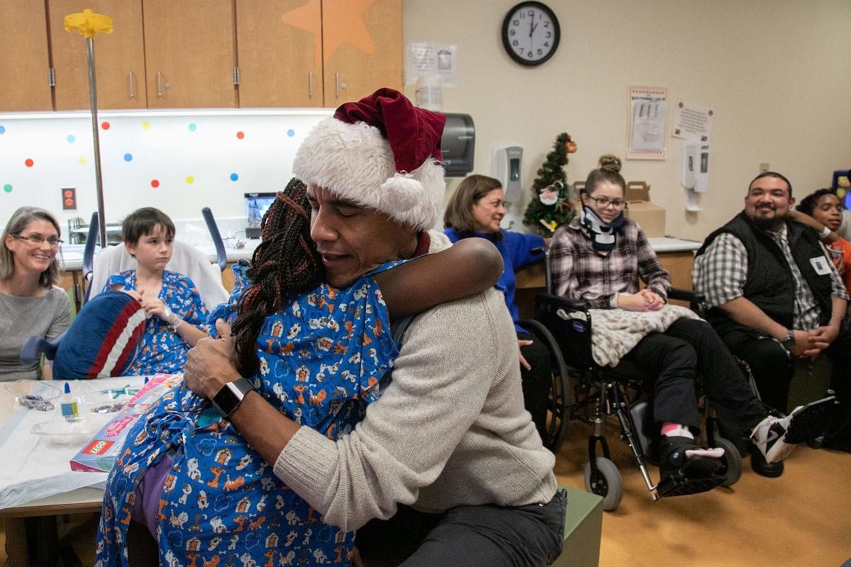 This photograph, obtained courtesy of the Obama Foundation, shows former US President Barack Obama delivering gifts, greeting patients and their parents at Children’s National Medical Center in Washington, DC,December 19, 2018. (Photo by Chuck Kennedy / AFP)