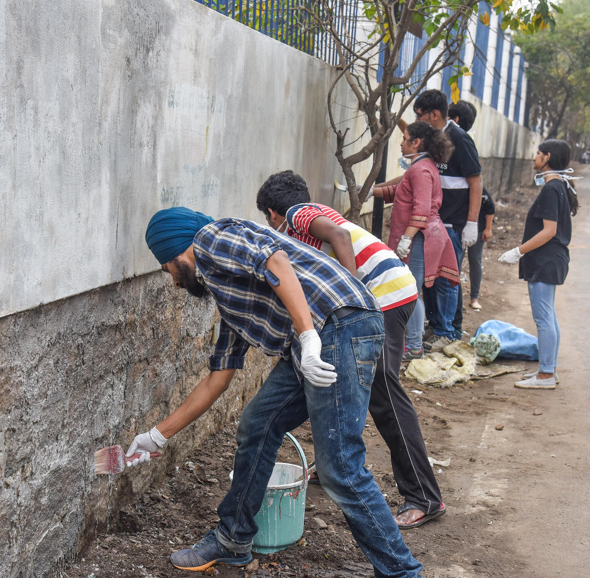 Students, volunteers whitewash walls to smarten up city