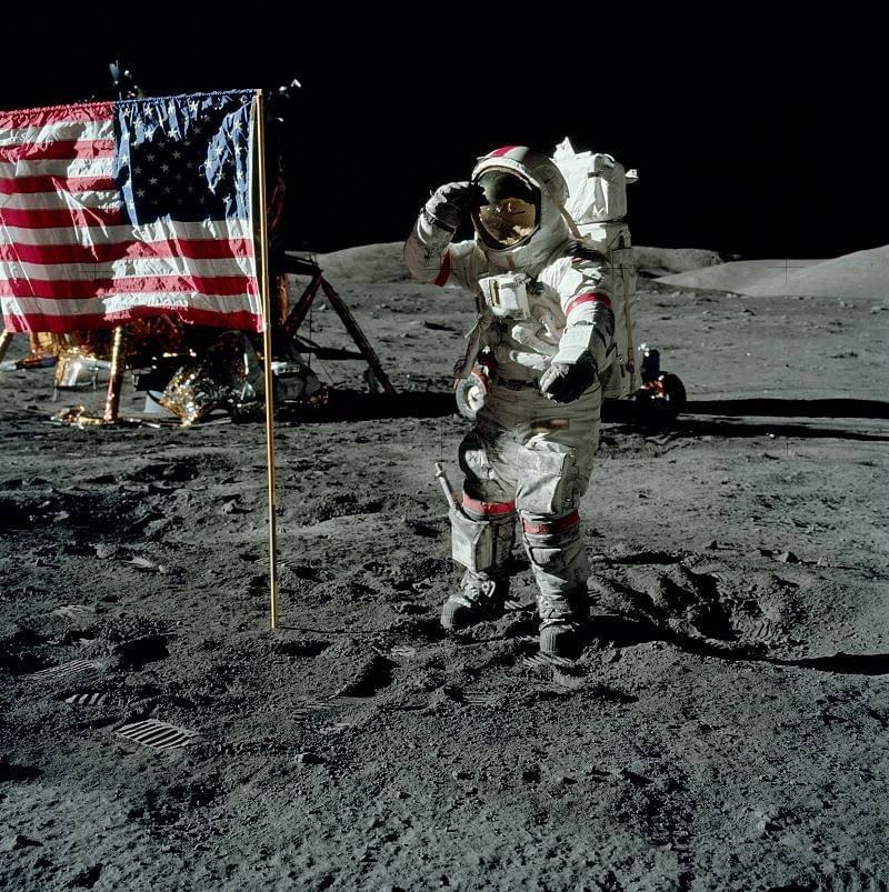 Gene is standing west of the flag, saluting. (Photo: NASA)
