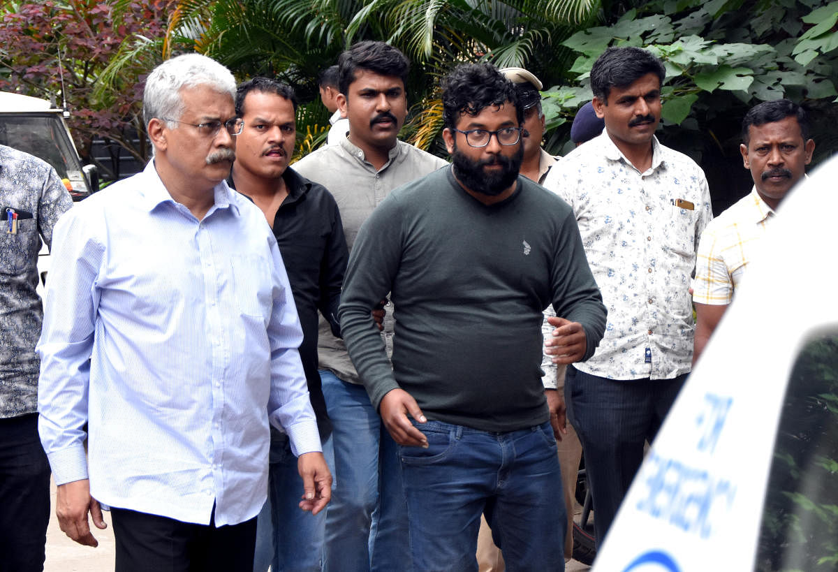 Alliance University Chancellor Sudhir G Angur (L) and his alleged henchman Suraj Singh (wearing specs) after their arrest. DH PHOTO