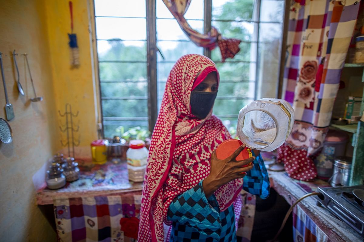 Khatoon displays the amount of grain she has left to feed her family. Dinner is often little more than homemade flatbread. Photographer: Prashanth Vishwanathan/Bloomberg