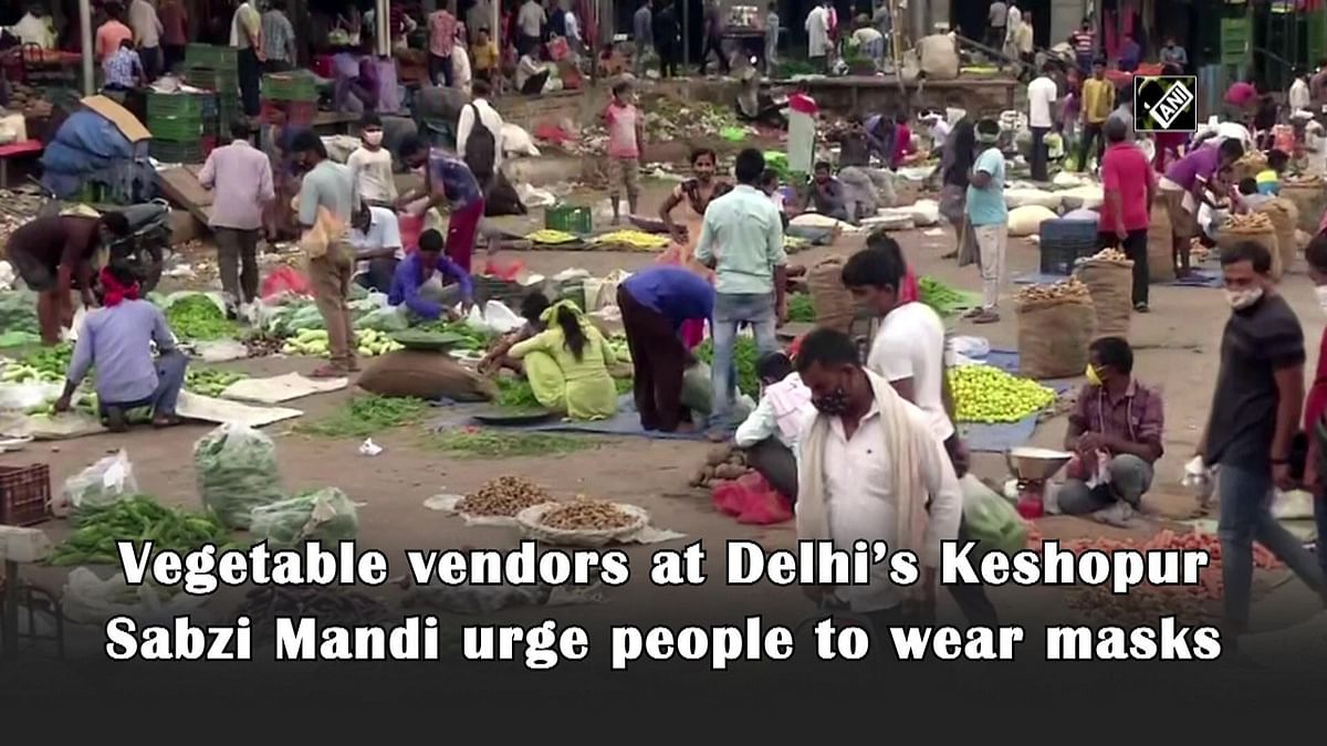 Vegetable vendors at Delhi’s Keshopur Sabzi Mandi urge people to wear masks 