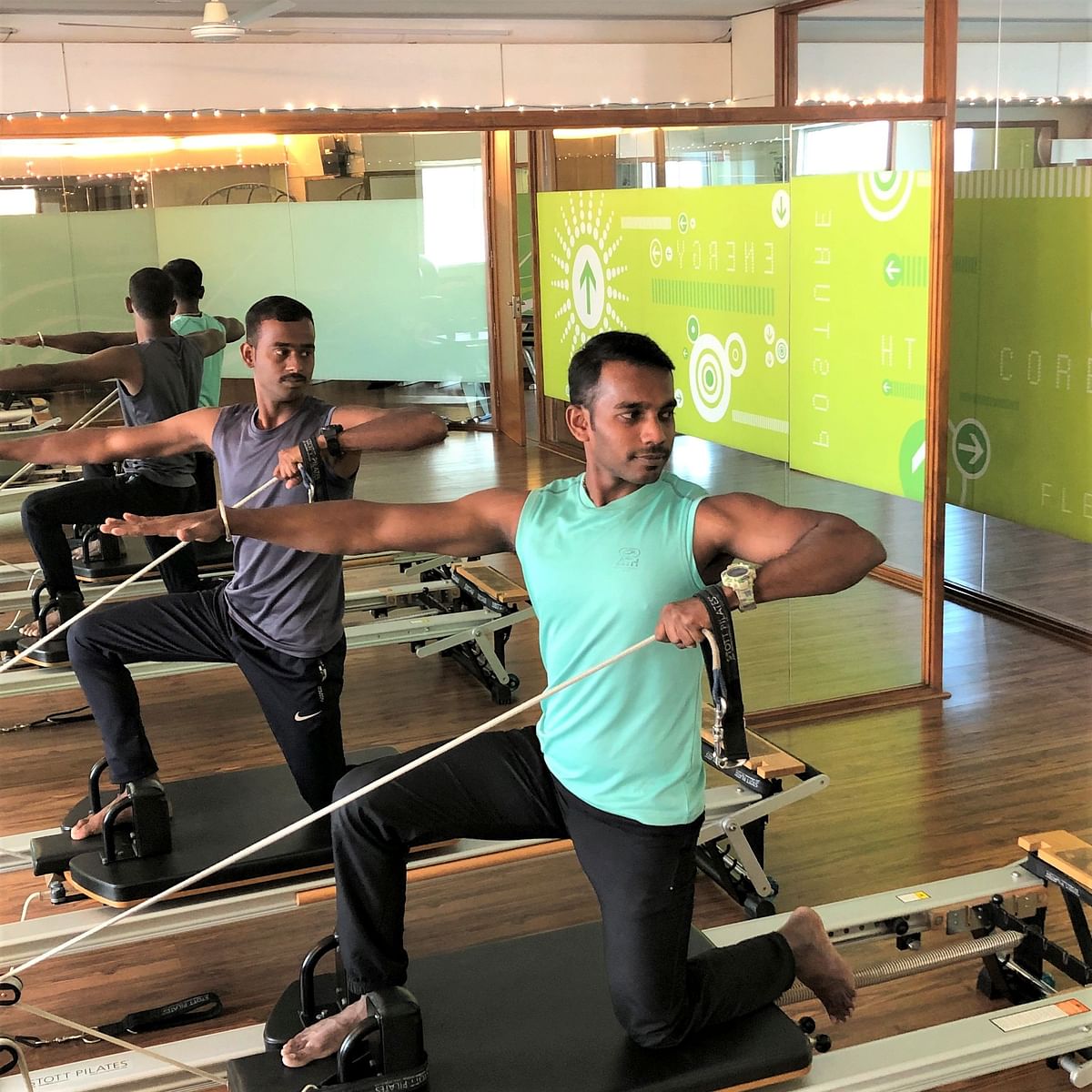 A single-arm row with rotation in a half lunge positionon the Reformer's moving platform