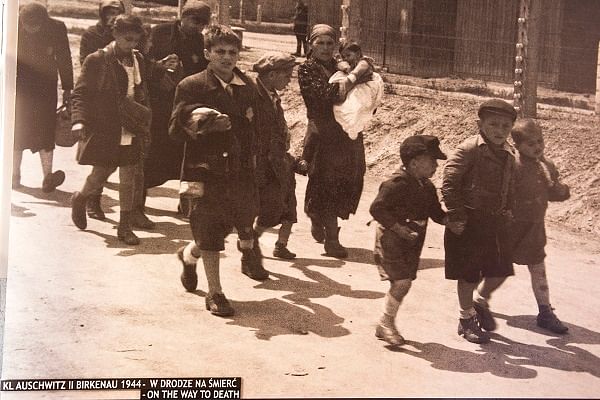A photograph capturing children and women walking towards the gas chambers