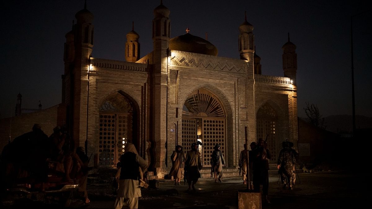 Taliban fighters walk at the entrance of the Eidgah Mosque after an explosion in Kabul, Afghanistan. Credit: AP/PTI Photo