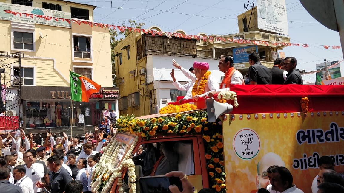 Amit Shah waves to the crowd at his roadshow in Ahmedabad's Naranpura area.