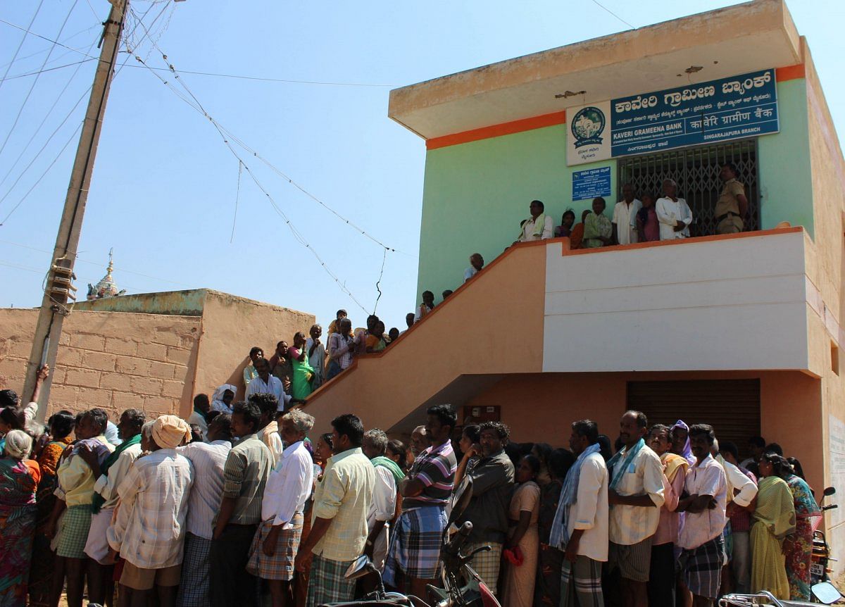 The photograph shows people in a long currency queueat Kavery Rural Development Bank Ramanagar, Karnataka. DH Photo