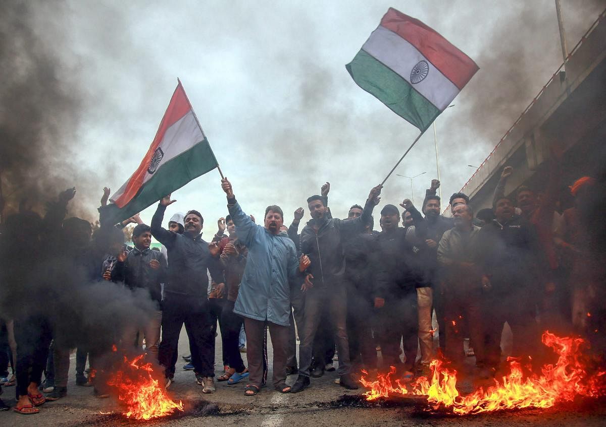 Protesters raise slogans and burn tyres during a demonstration against the Pulwama terror attack in Jammu on Friday. (PTI Photo)