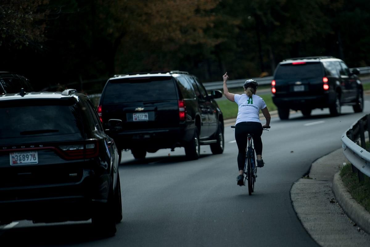 In this file photo taken on October 29, 2017 Juli Briskman gestures with her middle finger as a motorcade with US President Donald Trump departsTrump National Golf Course in Sterling, Virginia. (AFP)