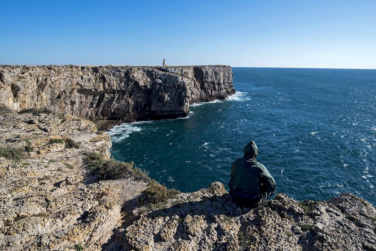 Sagres, Portugal - fisherman on the edge of the windswept cliffs of the 16th-century fort built by Dom Henry the Navigator