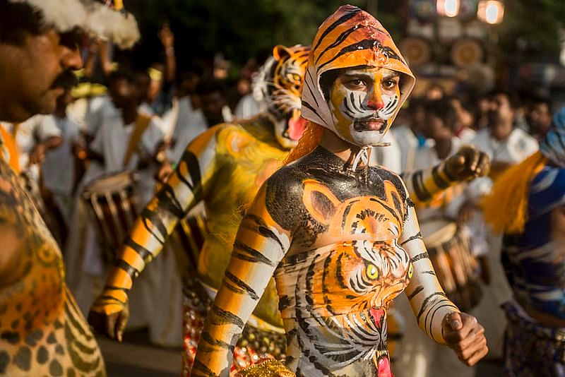 Pulikali, is a celebration during Onam where people dress up, usually with tiger body painting and masks.Above is a woman (Rehana Fathima) with body art with her male colleagues celebrating the festival of Hinduism in the streets of Kerala.