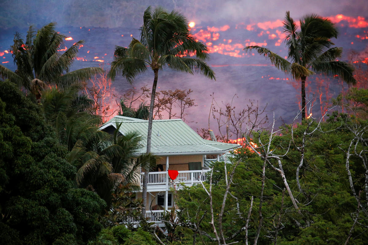 Lava flows near a house on the outskirts of Pahoa during ongoing eruptions of the Kilauea Volcano in Hawaii, U.S., May 19, 2018. REUTERS