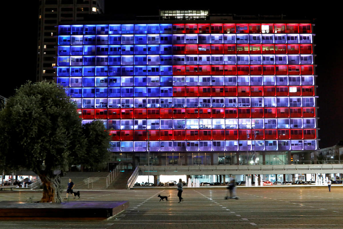 People walk by as the municipality building in Tel Aviv is lit in the colours of the American flag in solidarity with the victims of the Pittsburgh synagogue attack, Israel October 27, 2018 REUTERS/Nir Elias