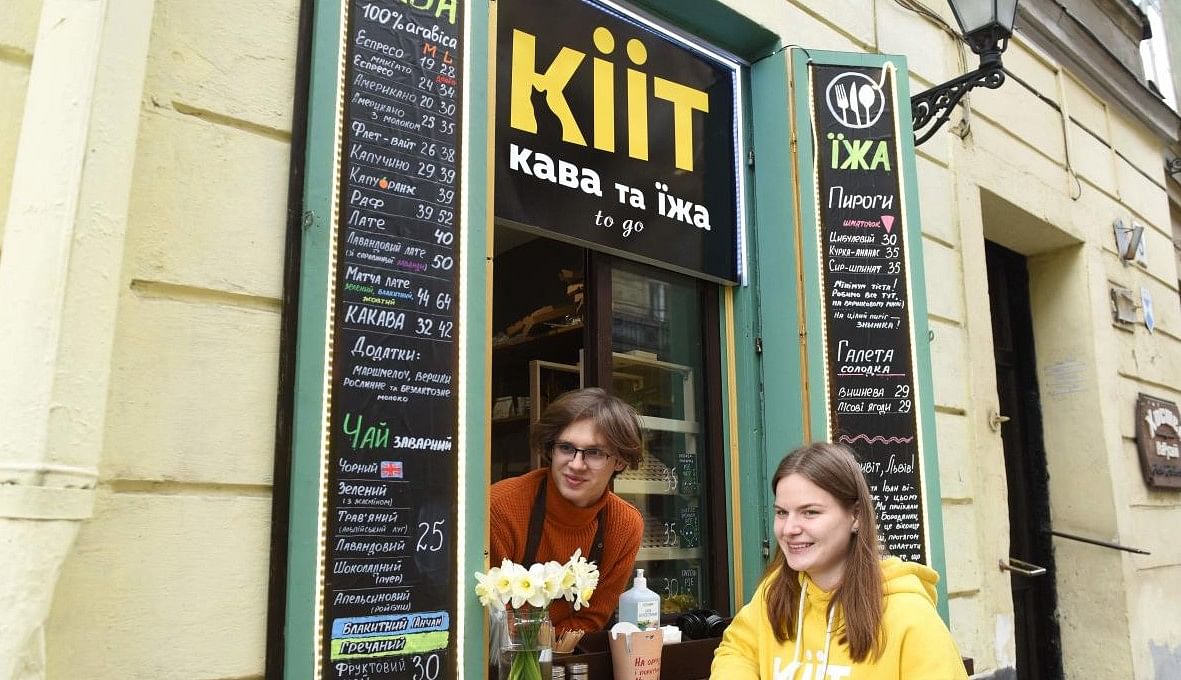 Ivan Denchenko (L), 19, and Daryna Mazur (R), 21, who work at the Kiit cafe, pose for a photo in the western Ukrainian city of Lviv on April 12, 2022. Credit: AFP