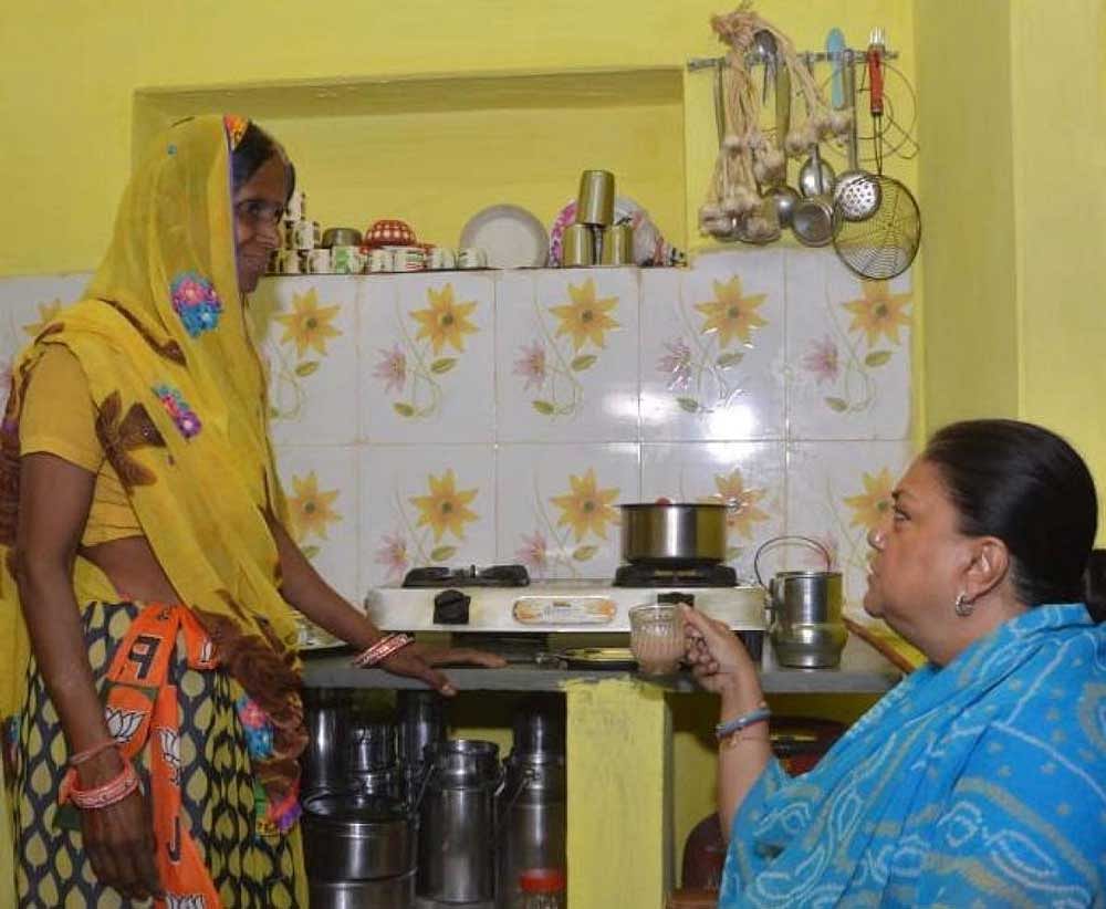 Chief Minister Vasundhara Raje has tea with a supporter at the latter's house. DH PHOTO